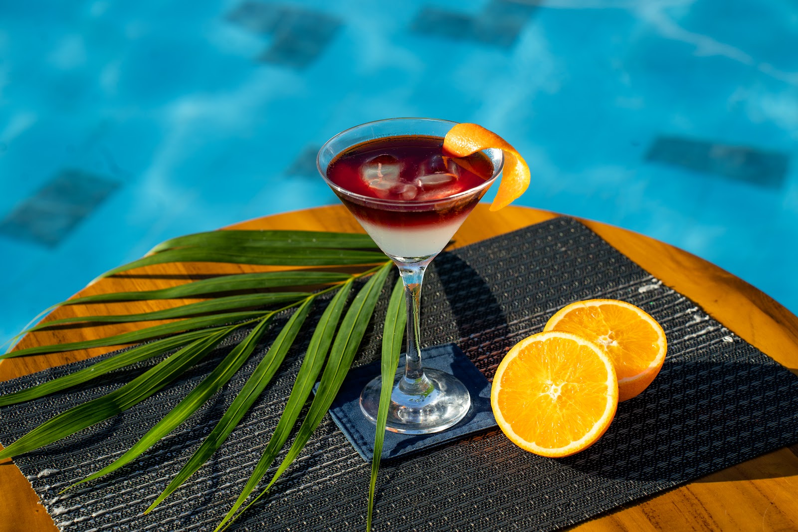 Cocktail with orange slices by the pool