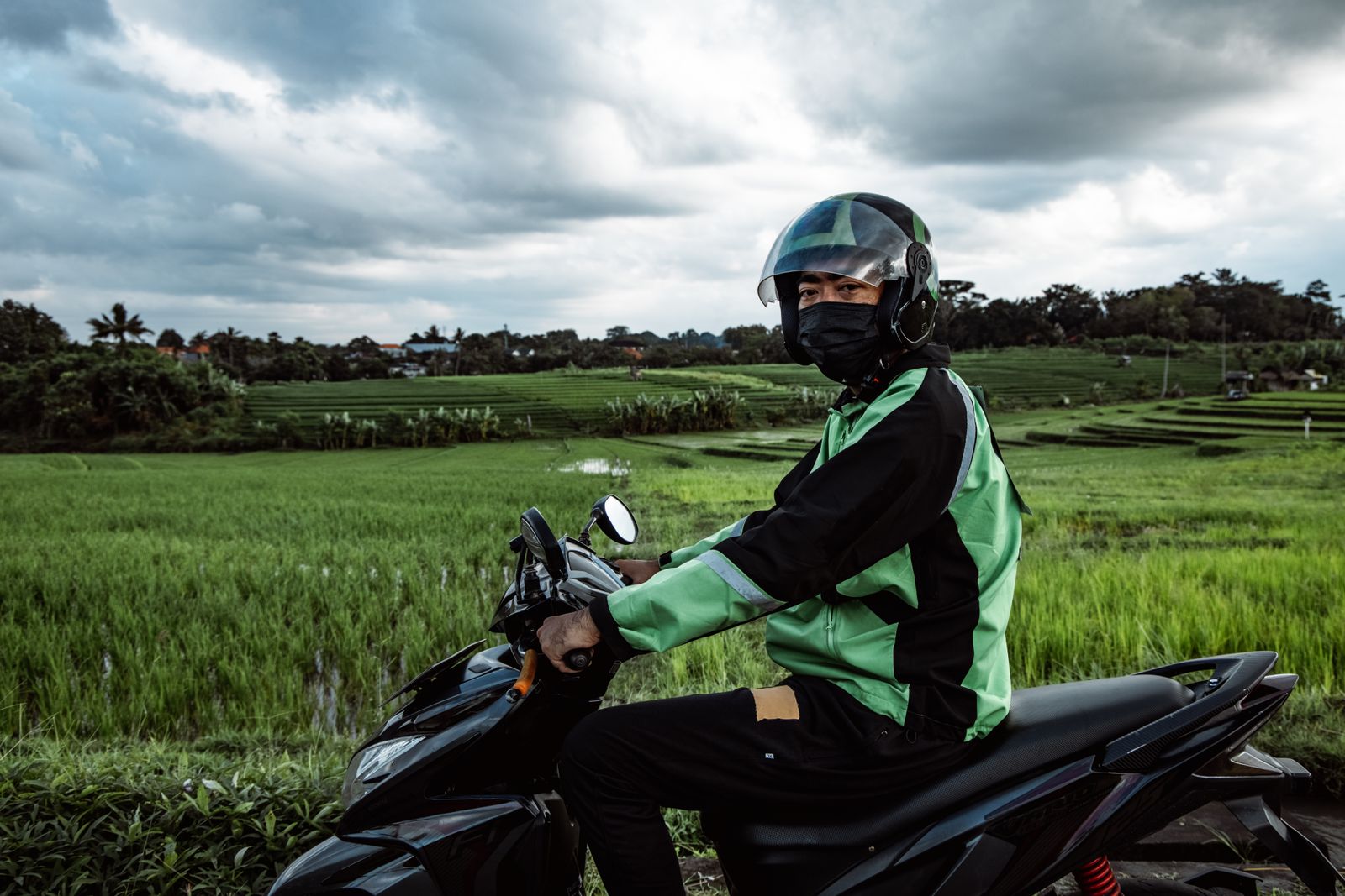 Scooter rider wearing a helmet on a rural road