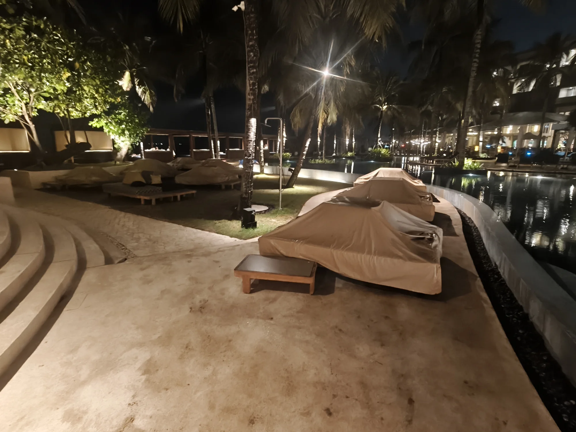 Private daybed beside the pool at night