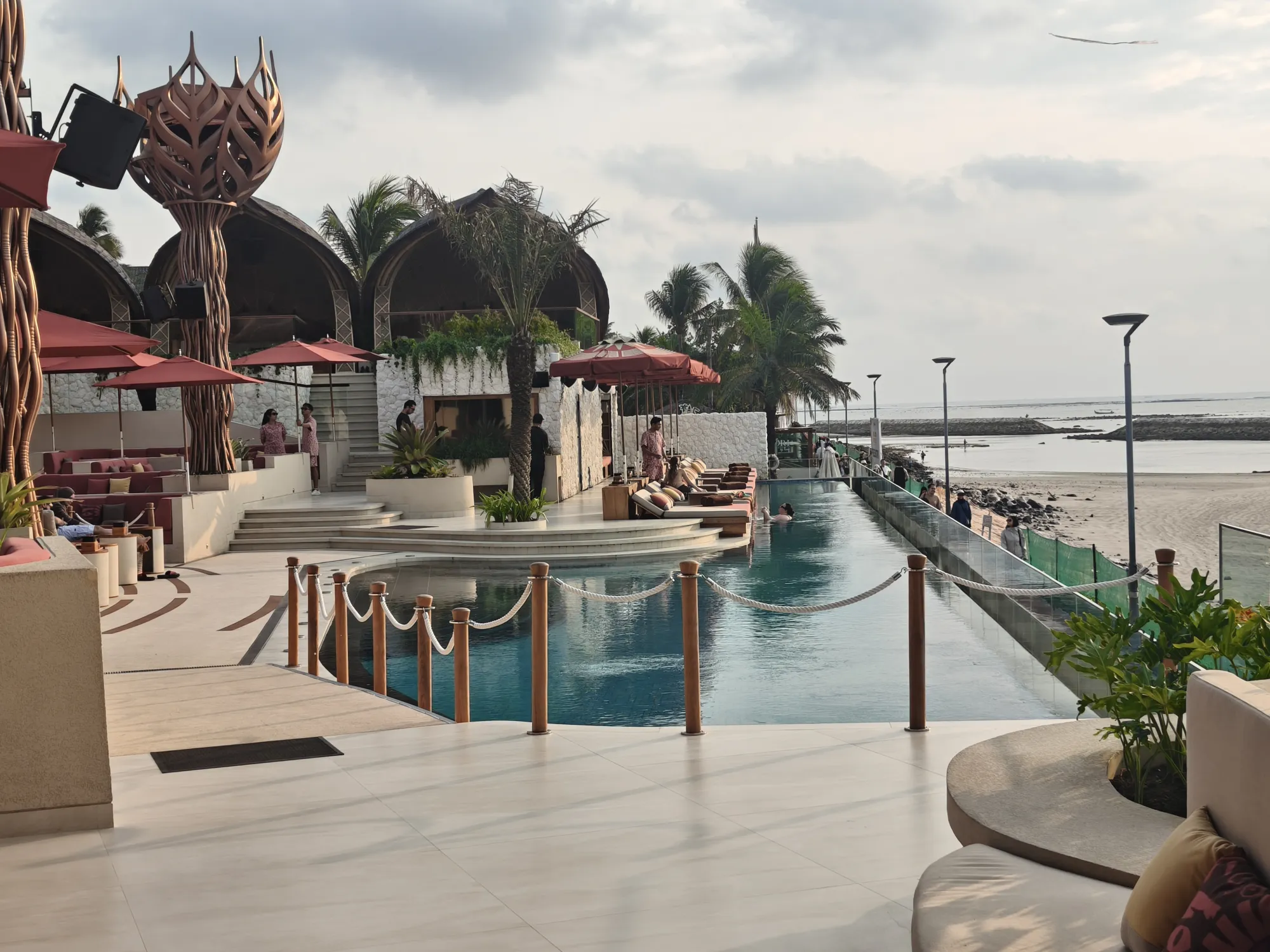 Infinity pool with daybeds facing the sea at Zumana Bali